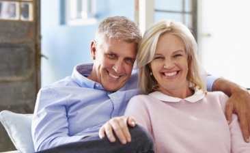 Senior man and woman sitting together on couch
