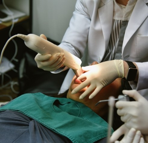 Dentist taking a digital scan of a patients teeth