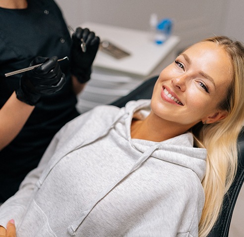 Woman smiling while sitting in dental treatment chair