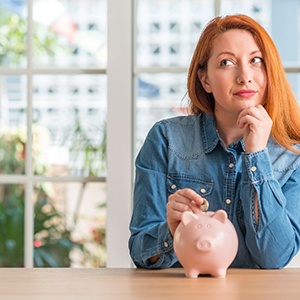 Woman putting coin into a piggy bank