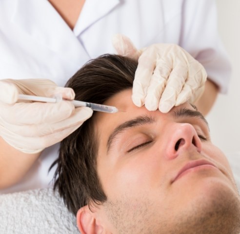 Man receiving injection in his forehead