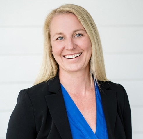 Doctor Arnold smiling in blue blouse and black blazer