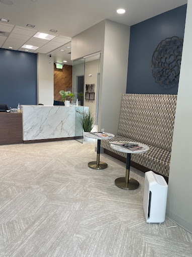 Front desk and two end tables in reception area of Parker dental office