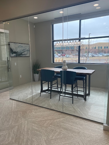 Room with glass wall and doors with a wood table with a vase