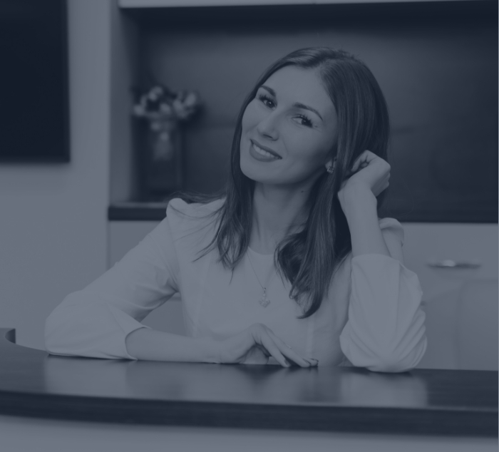 Smiling dental team member sitting behind front desk